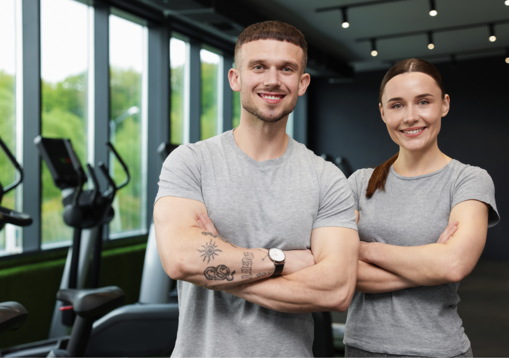 Deux coachs, un homme et une femme avec des t-shirts gris devant des vélos écliptiques devenu dirigeant d'un club indépendant.